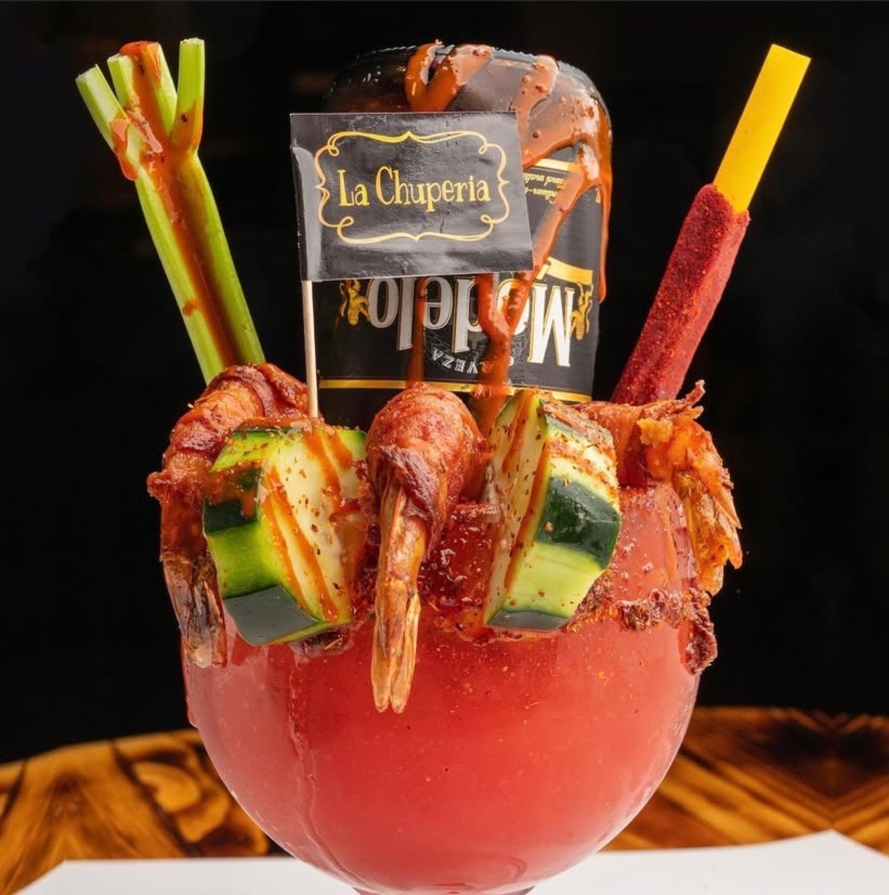 The Chuper Michelada — chamoy-rimmed goblet, inverted Modelo, shrimp and cucumber